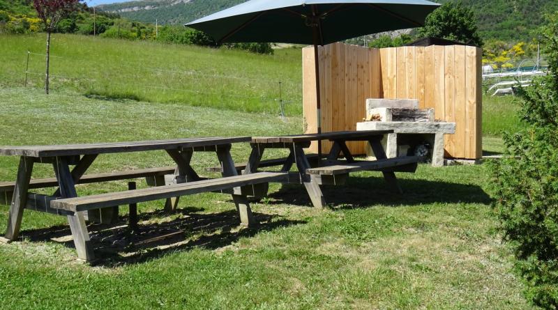 Barbecue et espace repas dans le jardin.